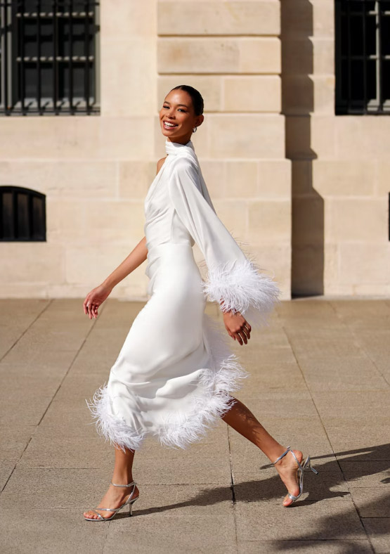 In questa foto una modella passeggia indossando un abito da sposa della collezione Patbo 2023