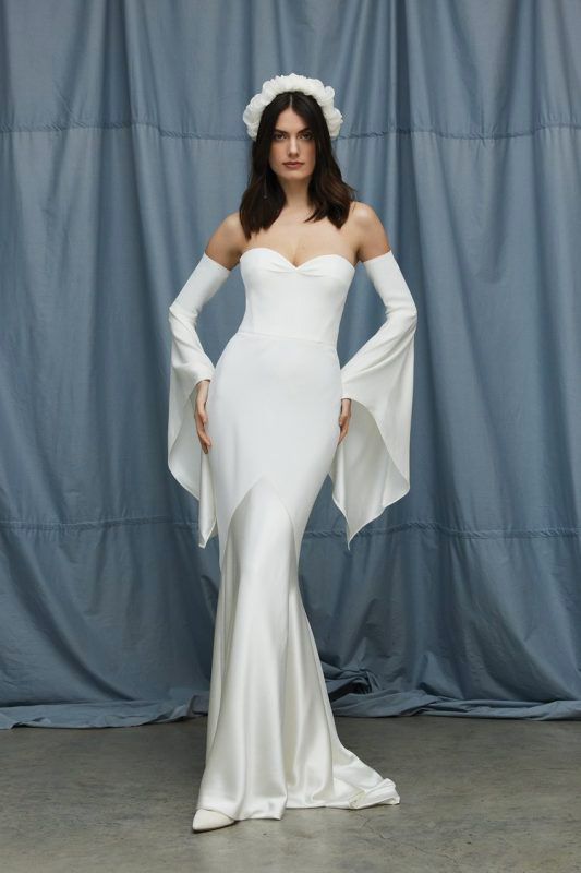 In questa foto una modella posa con un abito da sposa della collezione Savannah Miller 2023