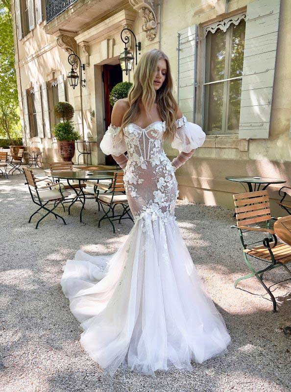 In questa foto una modella indossa un sexy abito a sirena, con bustier e maniche a palloncino, del brand Tom Sebastien per la stagione Bridal 2023