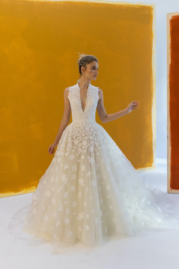 In questa foto una modella posa indossando un abito da sposa con scollo Queen Anne e senza maniche, dello stilista Peter Langner per la stagione Autunno 2023