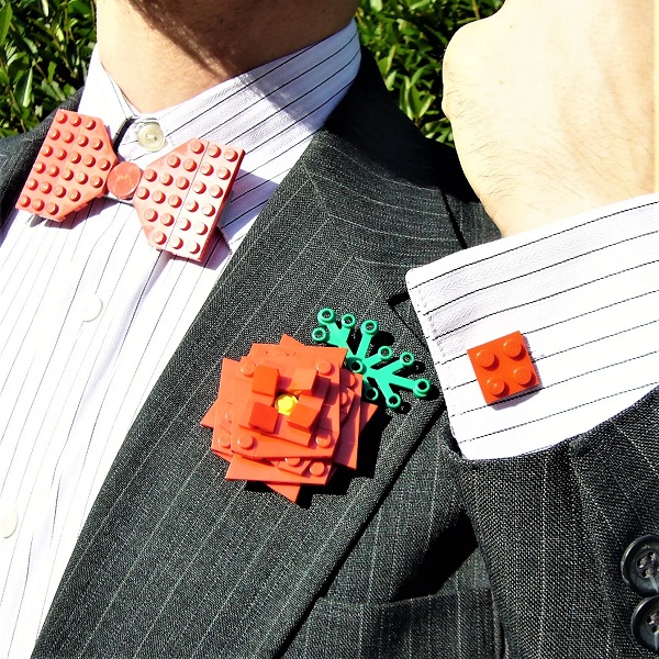 In questa foto, uno sposo indossa papillon, gemelli e boutonnière floreale tutti realizzati con mattoncini Lego rossi 