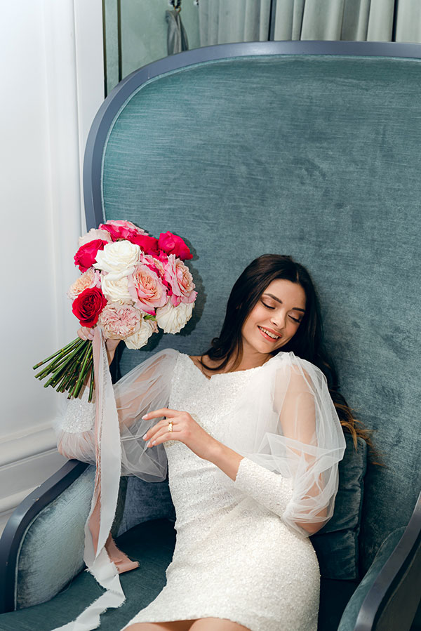 In questa foto un bouquet di Sara Tusset Floral Designer tra le mani di una modella vestita di bianco