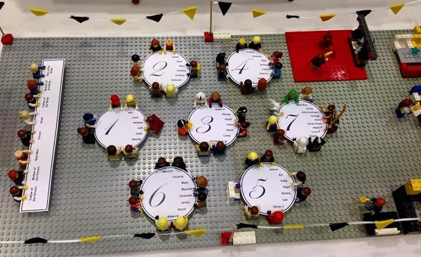 In questa foto, un tableau de mariage d'appoggio che ripropone la disposizione dei tavoli in versione Lego