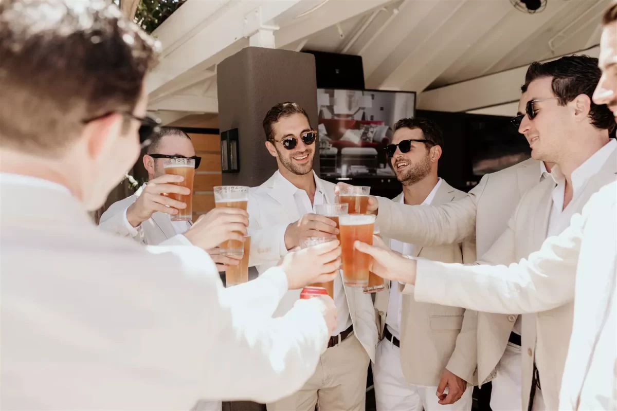 In questa foto lo sposo brinda con i suoi amici con bicchieri di birra per il suo addio al celibato