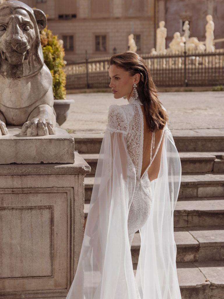 In questa foto una modella indossa un abito della nuova collezione di Pinella Passaro con scollo profondo sulla schiena
