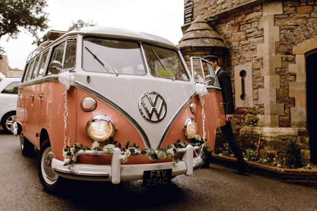 In questa foto un pullmino Volkswagen vintage di colore bianco e cachi decorato con coccarde e fiori