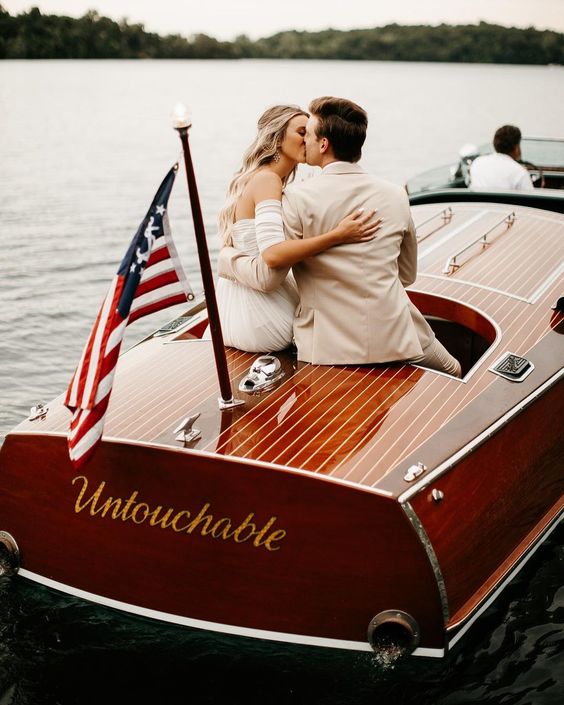In questa foto due sposi si baciano a bordo di una barca 