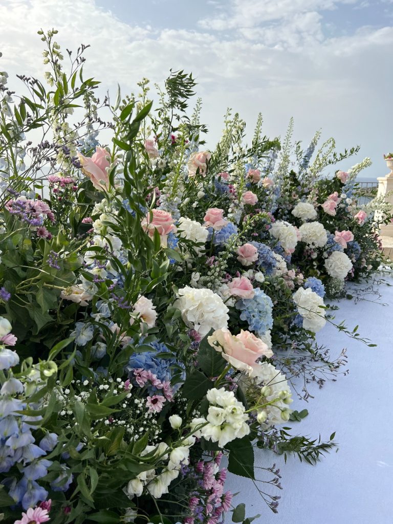 In questa foto un allestimento floreale bianco, celeste e rosa di Maria Mannino Floral Designer