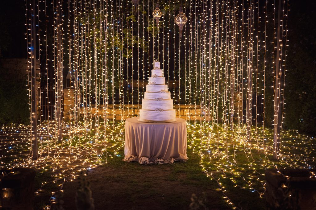 Il lightdesign con luci a forma di radici dietro la wedding cake del matrimonio di Carmen e Giuseppe, realizzato dalla Wedding Planner Melania Millesi
