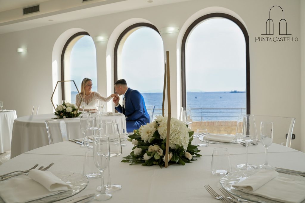 In questa foto una coppia di sposi nella sala panoramica all'Hotel Punta Secca