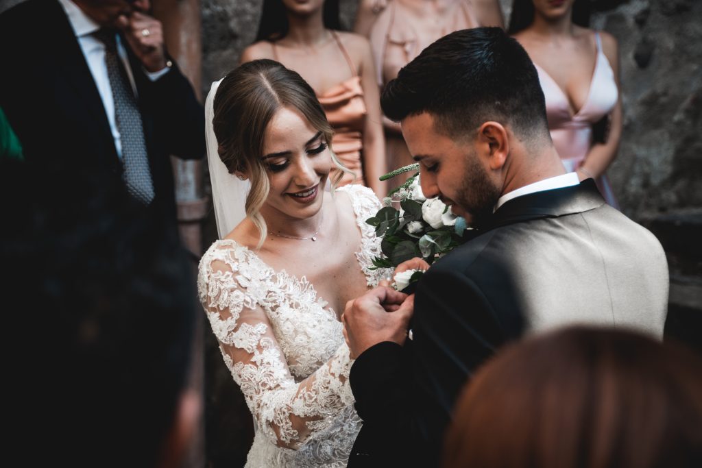 In questa foto il matrimonio di Giulia e Giuseppe organizzato dalla wedding planner Rossella Giuffrida: la sposa sistema l'abito allo sposo