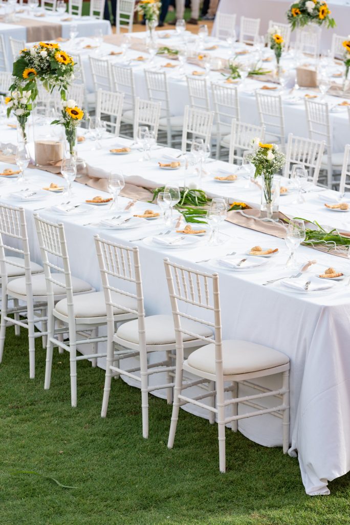 In questa foto un allestimento di matrimonio con tovaglie bianche e girasoli alla Tonnara dell'Orsa