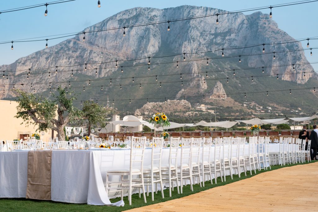 In questa foto un allestimento di matrimonio con tovaglie bianche e girasoli alla Tonnara dell'Orsa