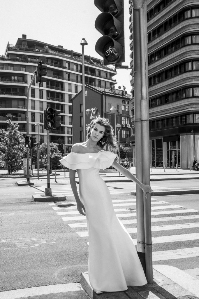 In questa immagine un abito da sposa Elisabetta Polignano 2023 minimal e con scollo a barca.