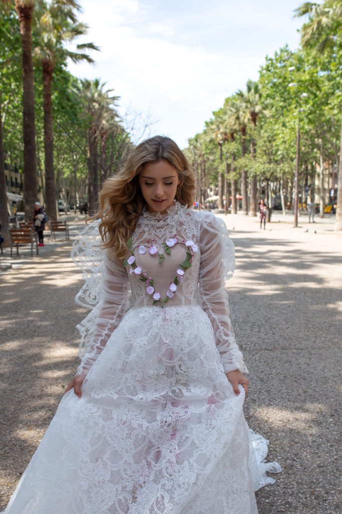 In questa immagine un abito da sposa Rara Avis con un cuore sul corpetto decorato da fiori in argilla. 