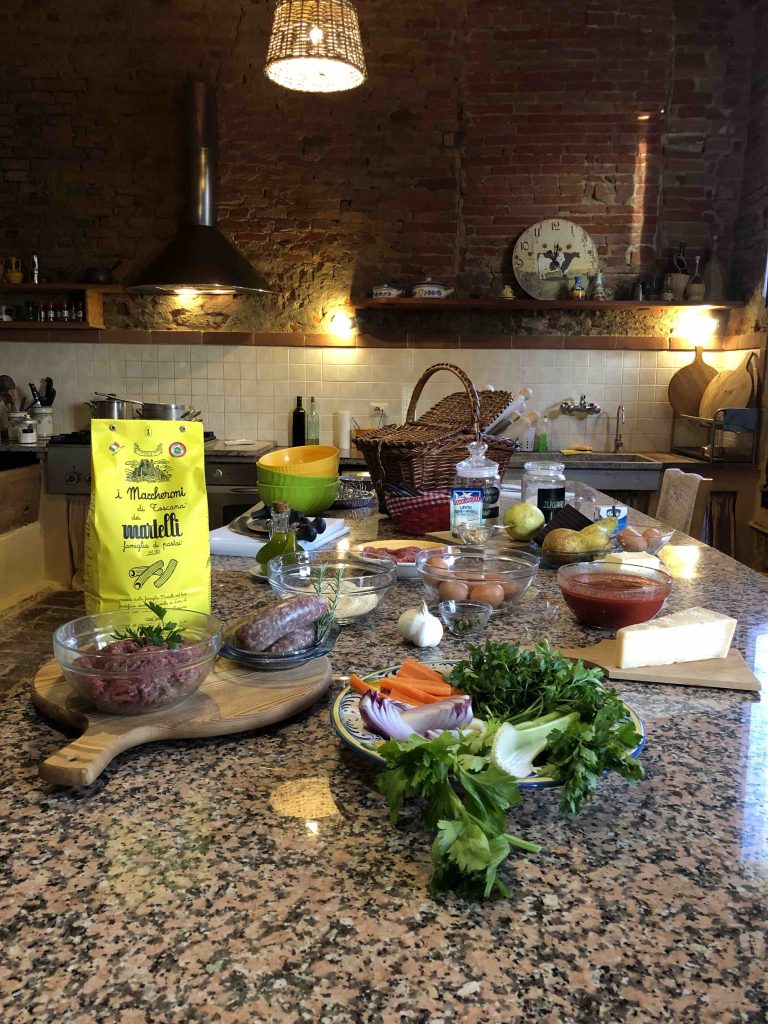 In questa foto tutti i prodotti alimentari utilizzati durante la cooking class. Sono posizionati sopra un grande tavolo in marmo, all'interno di quella che era la mangiatoia del casale di Montefoscoli