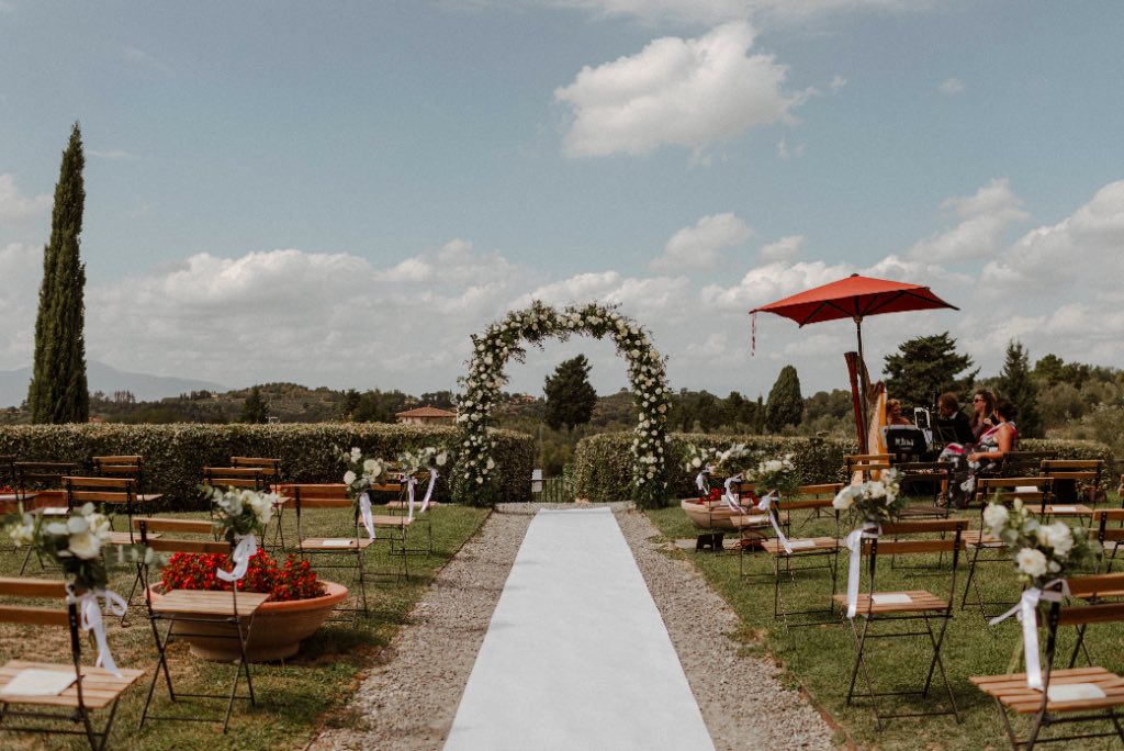 In questa foto uno dei giardini di Borgo Colleoli allestito con sedie e un arco di fiori, pronto ad ospitare la celebrazione di un matrimonio con rito civile