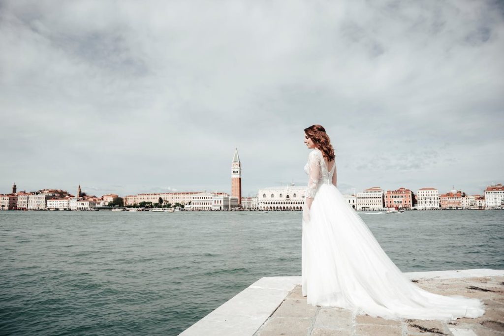 In questa foto la sposa Francesca posa sullo sfondo di Venezia. Sorridente, guarda verso il mare della laguna