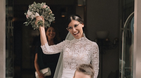 In questa foto la sposa Valentina mentre esce da casa mostrando il suo bouquet come fosse un trofeo