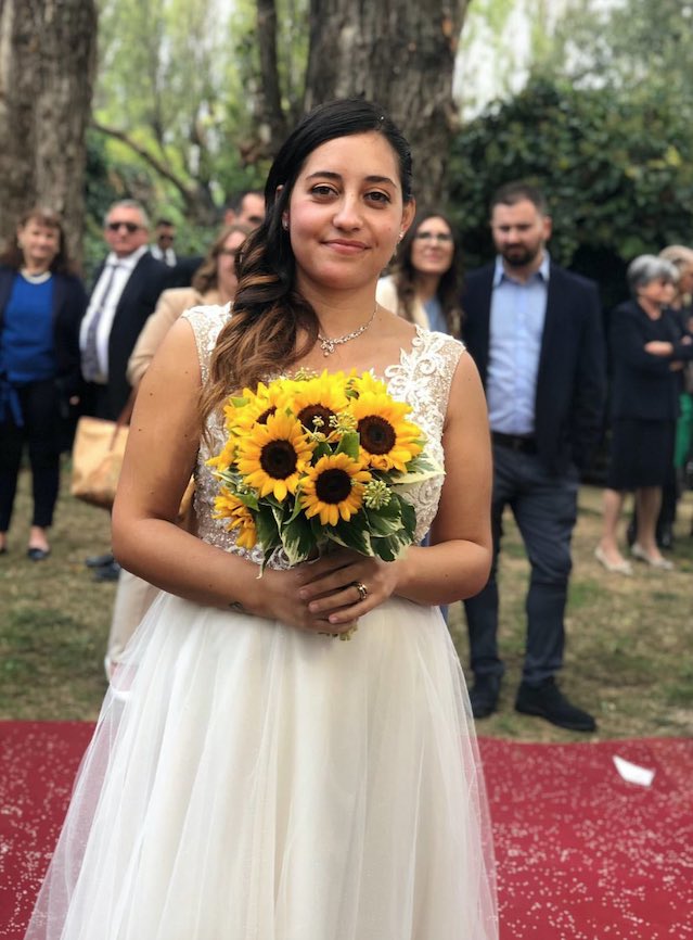 In questa foto la sposa Valentina, mentre regge tra le mani il suo bouquet di girasoli