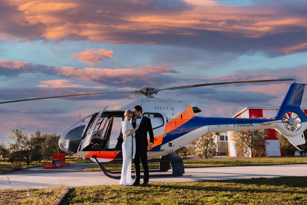 In questa foto una coppia di sposi che ha scelto un Destination Wedding con Diana Da Ros Wedding Planner pronta a salire su un elicottero