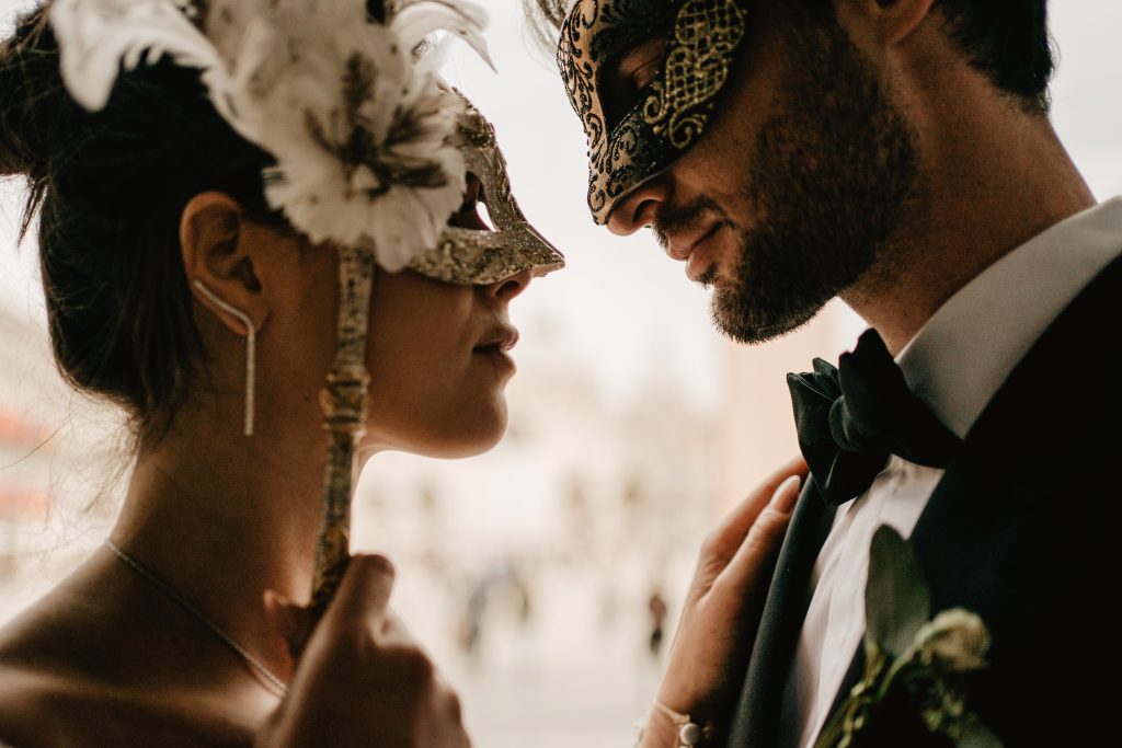 In questa foto una coppia di sposi in maschera a Venezia