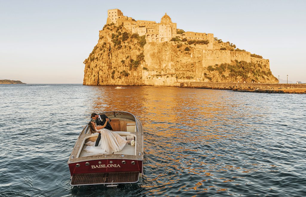 In questa foto una coppia di sposi in barca verso Ischia, una delle location preferite di Diana Da Ros Wedding Planner