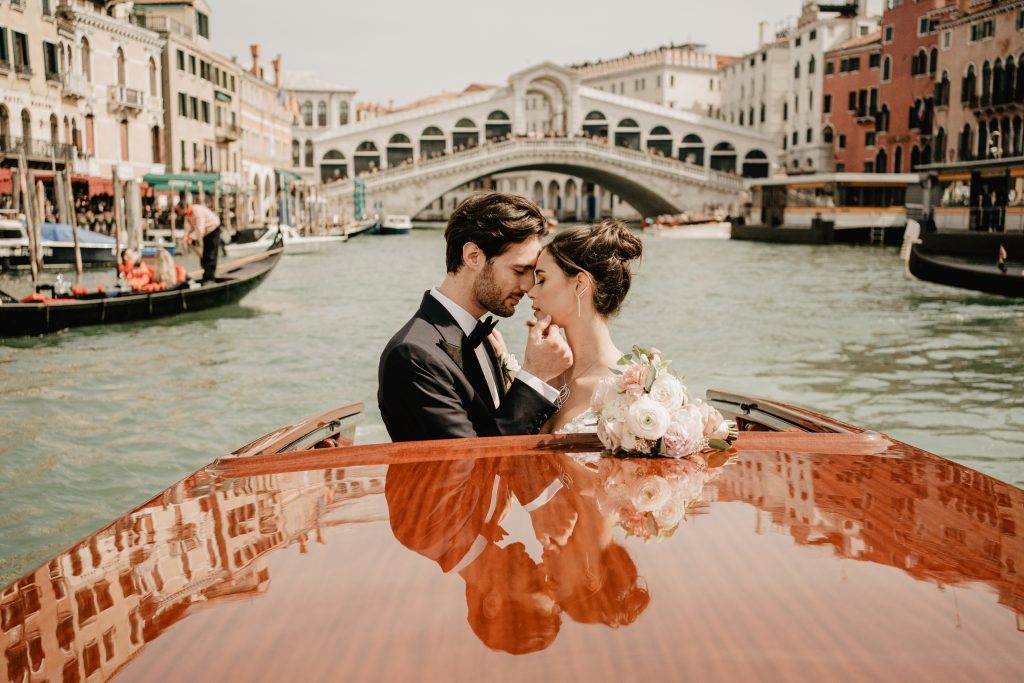 In questa foto una coppia di sposi in un battello nella laguna di Venezia, una delle location preferite di Diana Da Ros Wedding Planner