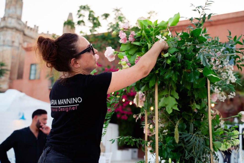 In questa foto la flower designer Maria Mannino, scelta da Paola Pizzo e dal marito Carlo Averna, mentre è intenta a sistemare i fiori nella banchina della location dove si è svolto il ricevimento 