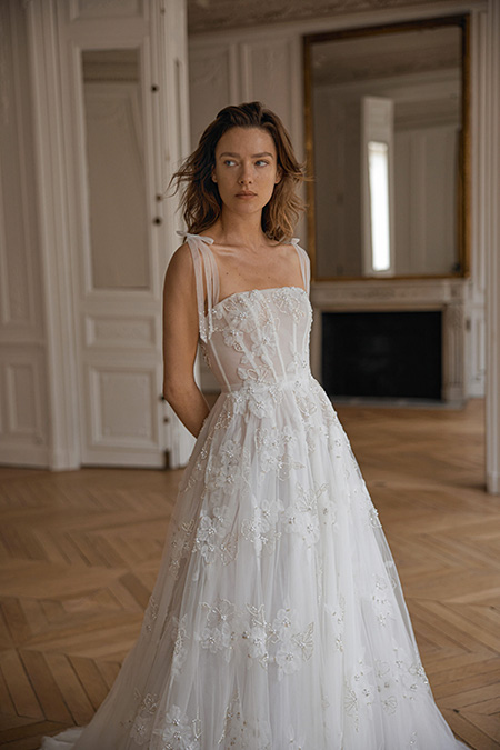 In questa foto la modella indossa un abito da sposa con bustino steccato e decoro floreale Eisen Stein
