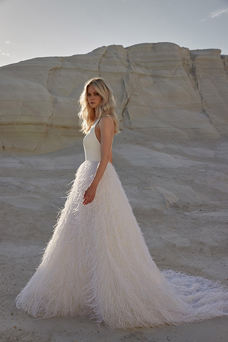 In questa foto la modella indossa un abito da sposa con piume Sassi Holford