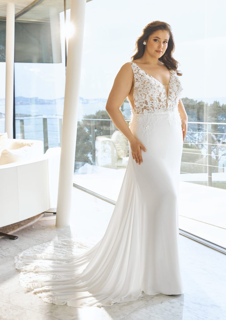 Uno degli abiti da sposa curvy 2023 che fa parte della nuova collezione sposa Pronovias. Un modello con corpetto in pizzo e ampia gonna in seta.