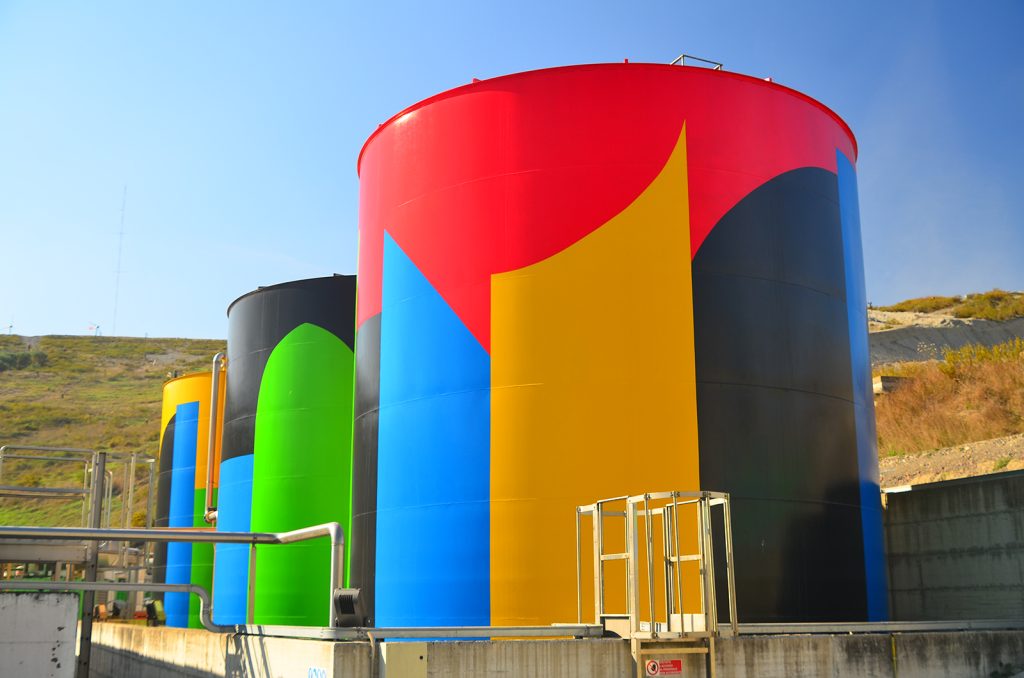 In questa foto uno dei silos della discarica di Legoli dipinto dall'artista britannico David Tremlet, che ne ha fatto così un'opera visiva d'arte contemporanea