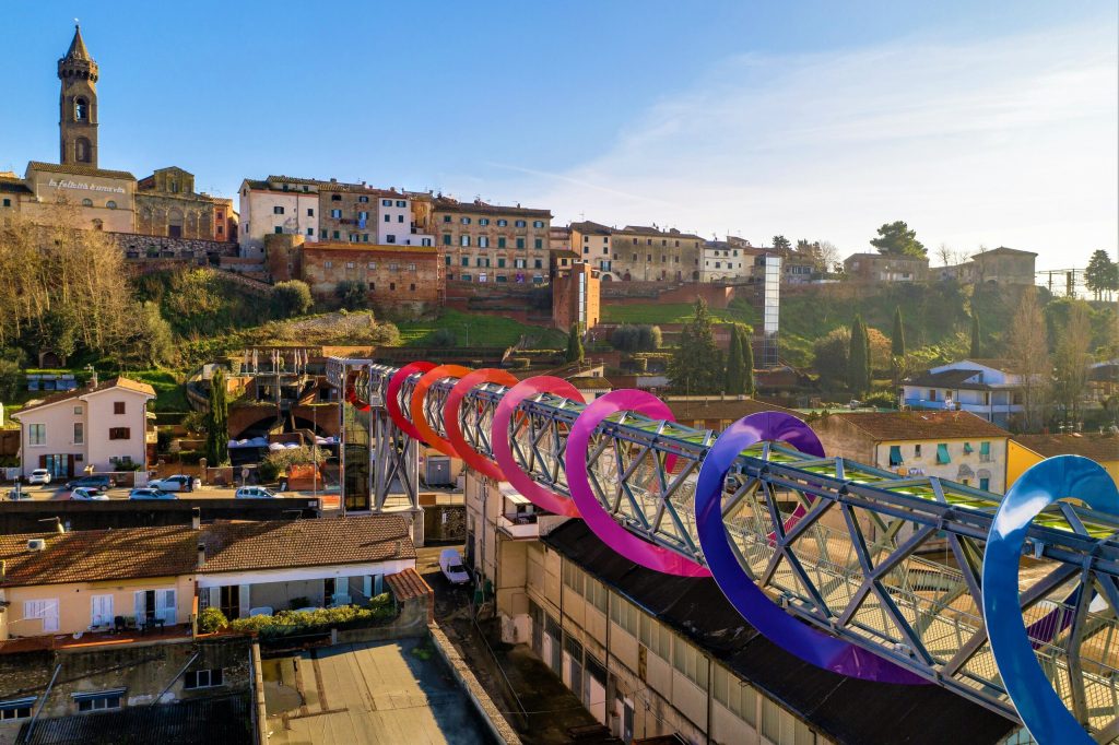 In questa foto il sovrappasso di Peccioli avvolto da una spirale colorata e ipnotica che rappresenta, in ordine di tempo, una delle ultime installazioni artistiche realizzate nel paese toscano