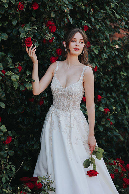 In questa foto la modella indossa un abito da sposa disney modello Belle con corpetto steccato con motivi floreali in trasparenza