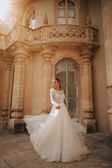 In questa foto la modella indossa un abito da sposa disney modello Jasmine con gonna di tulle e maniche lunghe