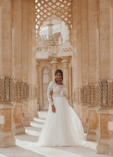 In questa foto la modella indossa un abito da sposa disney modello Jasmine con gonna di tulle e maniche lunghe