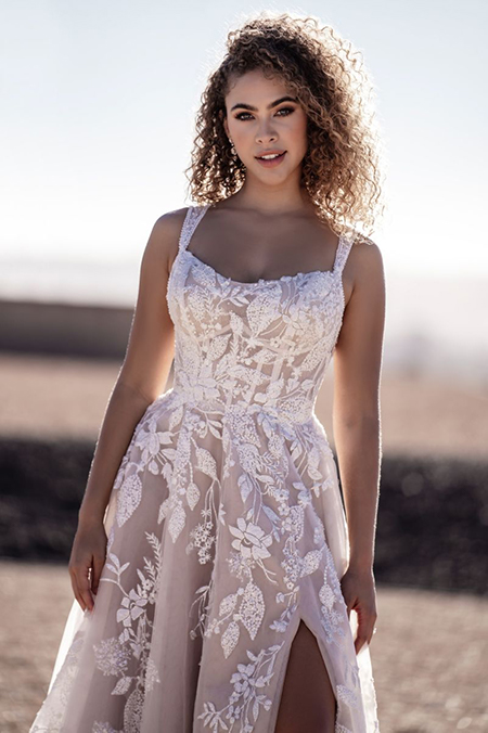 In questa foto la modella indossa un abito da sposa romantico 2023 con bustier con fiori e spacco laterale
