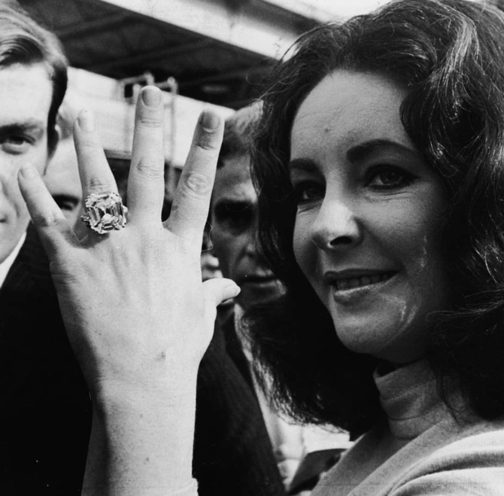 In questa foto Liz Taylor mostra il suo anello di fidanzamento con un grande diamante taglio smeraldo