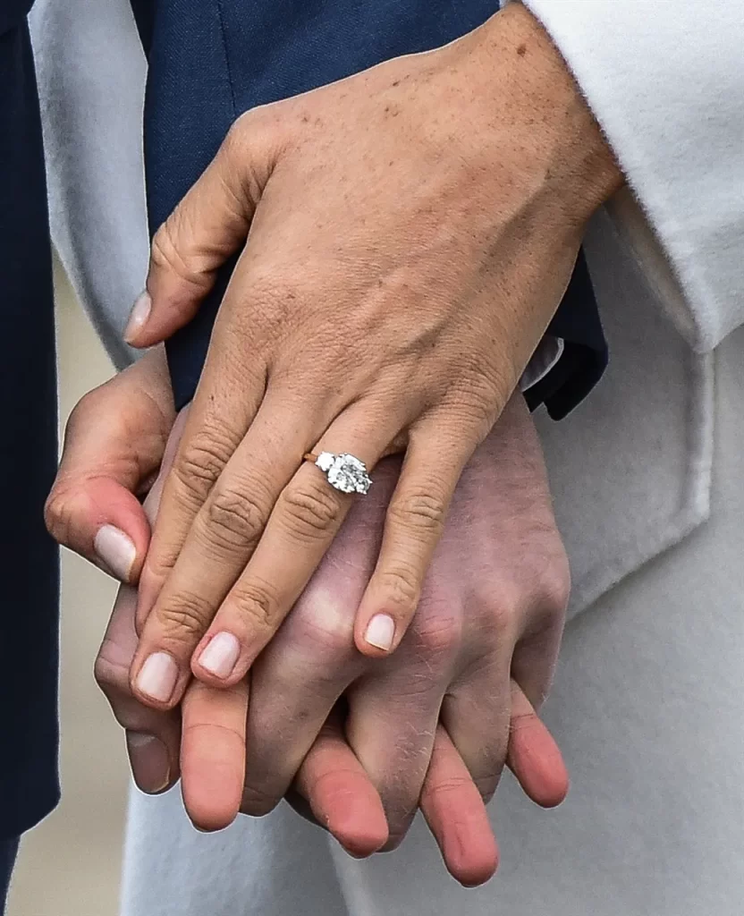 In questa foto la mano di Meghan Markle che stringe quella del principe Harry mostrando il suo anello di fidanzamento con un grande diamante al centro e due più piccoli ai lati