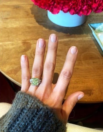 In questa foto l'anello di fidanzamento di Jennifer Lopez con un grande diamante verde taglio smeraldo e una fila di diamanti ai lati