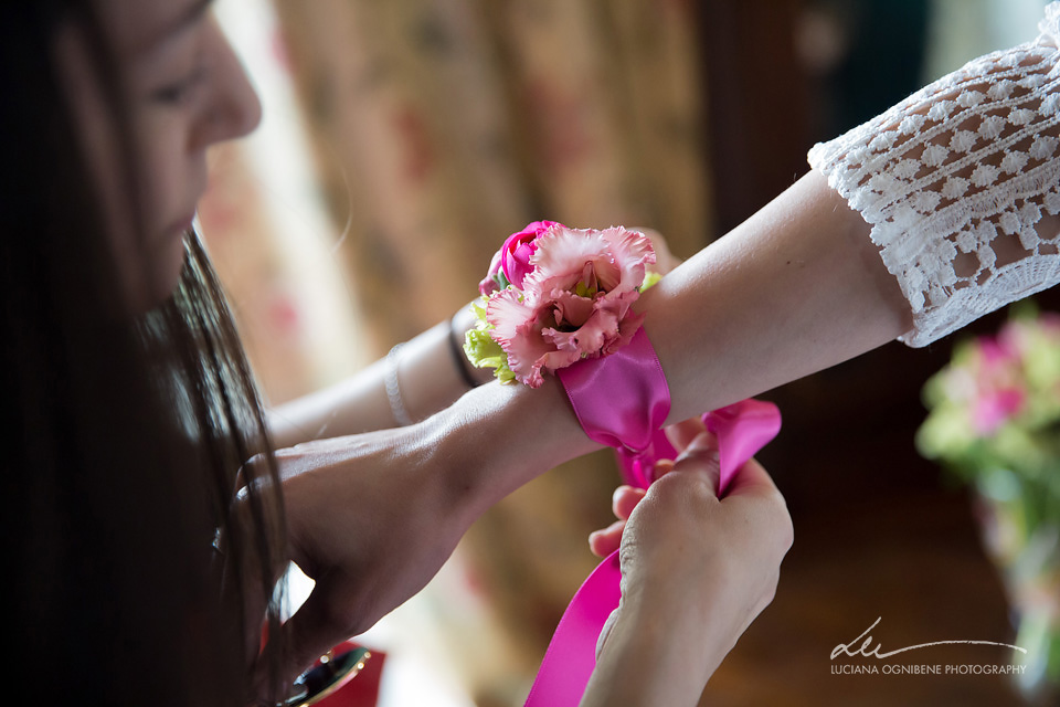 In questa foto un nastro colorato e un fiore al braccio di una sposa