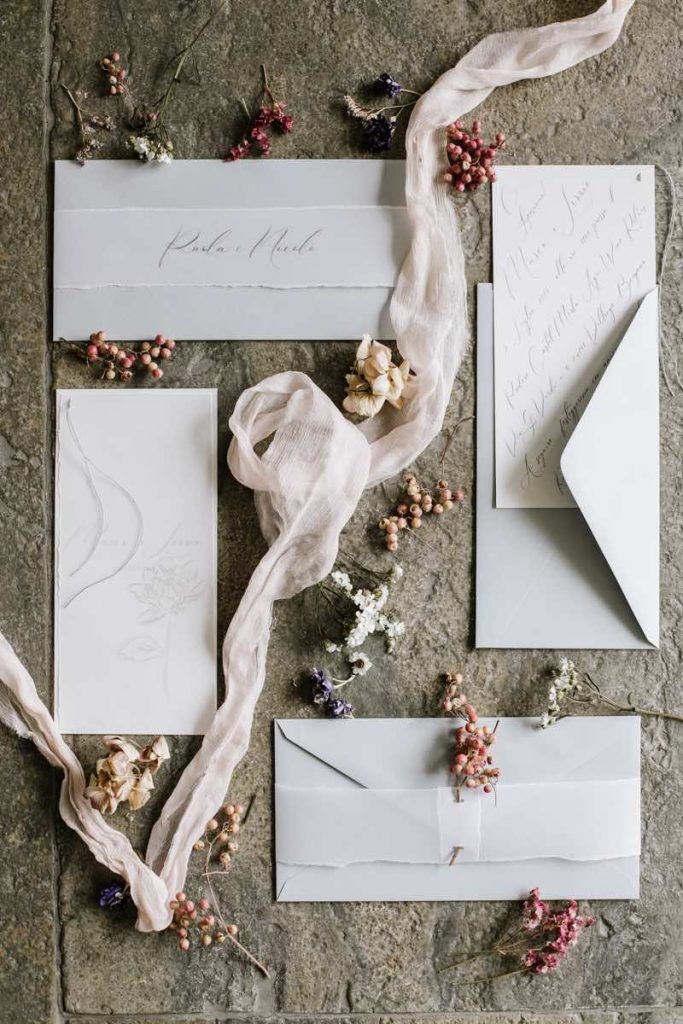 In questa foto un coordinato di matrimonio in stile minimal di colore verde chiaro e bianco con nastri di garza di colore bianco 