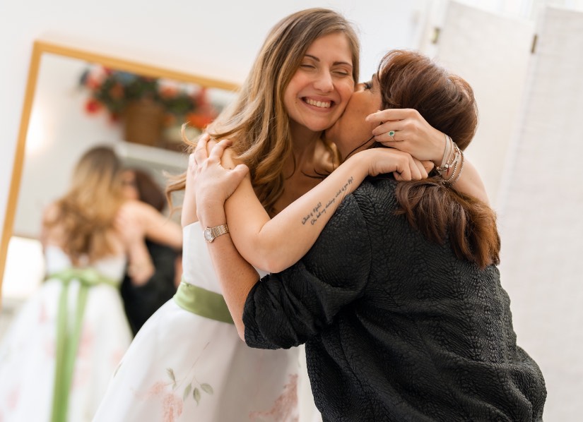 In questa foto la stilista di abiti da sposa Chiara Vitale abbraccia la direttrice di Sposi Magazine, Paola Pizzo, durante la prova dell'abito da sposa su misura che ha realizzato per le sue nozze