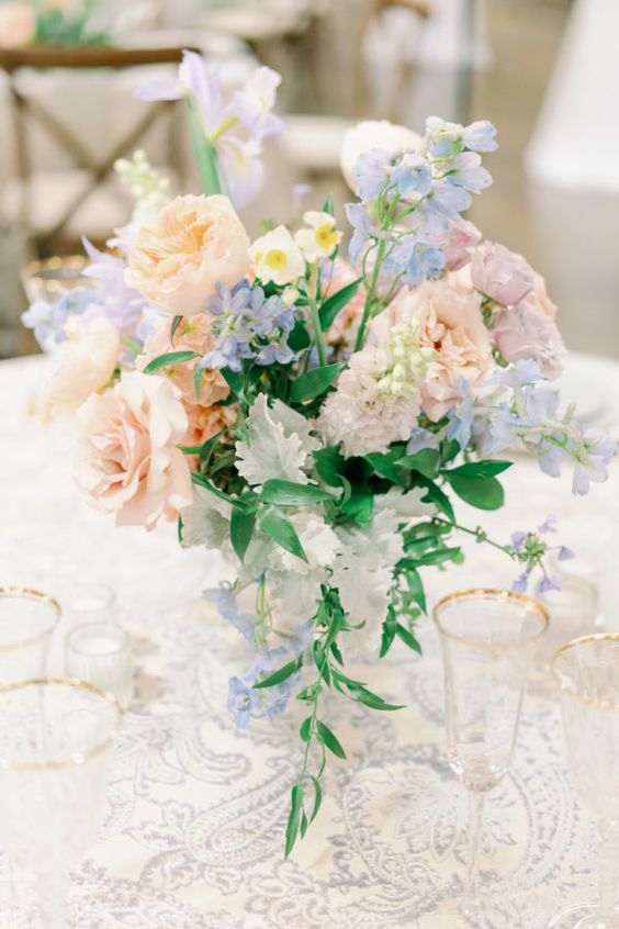 In questa foto un centrotavola con rose, ortensie e rose inglese di colore rosa pesca e celeste