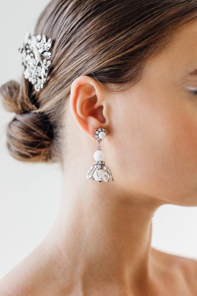 In questa foto orecchini pendenti in argento con perle di Maria Elena Headpieces
