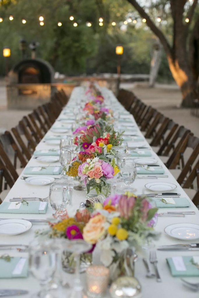 In questa foto un tavolo imperiale per matrimonio in stile Country Chic decorato con piccole composizioni di fiori colorati