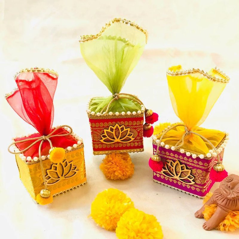 In questa foto scatole portaconfetti per matrimonio stile etnico con tulle colorato e decorazione a forma di fiore di loto