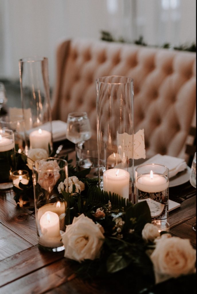 In questa foto decorazioni per matrimonio in stile industriale con portacandele di vetro trasparente, candele bianche e rosa cappuccino