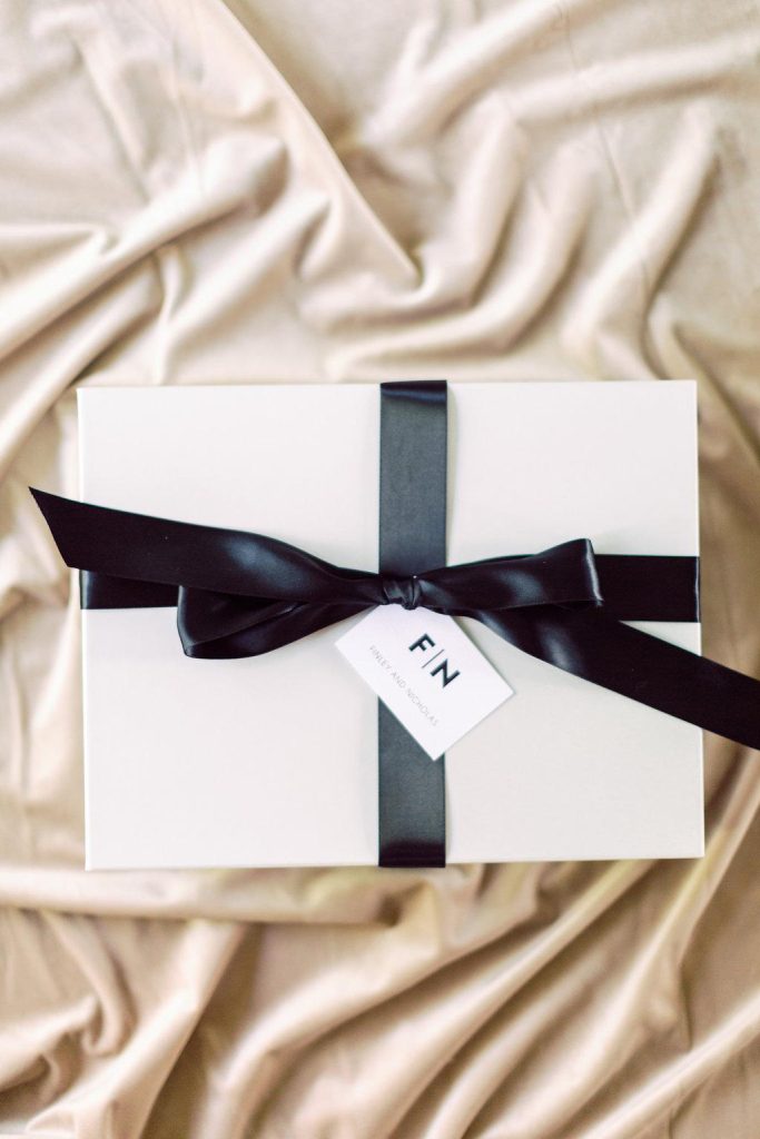 In questa foto una scatola bianca con nastro di colore nero da usare come bomboniere per matrimonio minimal